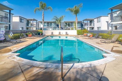 a swimming pool with palm trees in the background at Park Avenue Apartments, Long Beach, CA, 90815