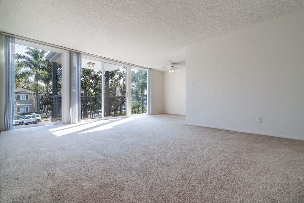 an empty living room with a sliding glass door leading to a patio at  Park Avenue Apartments, Long Beach