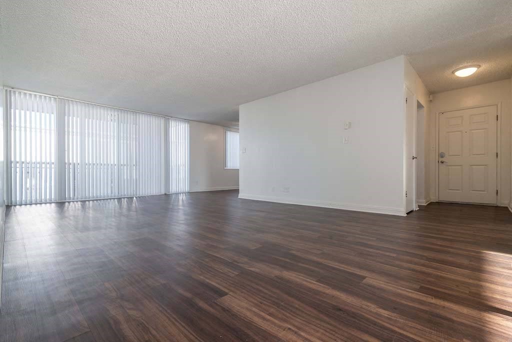 an empty living room with a large window at Park Avenue Apartments, Long Beach, CA
