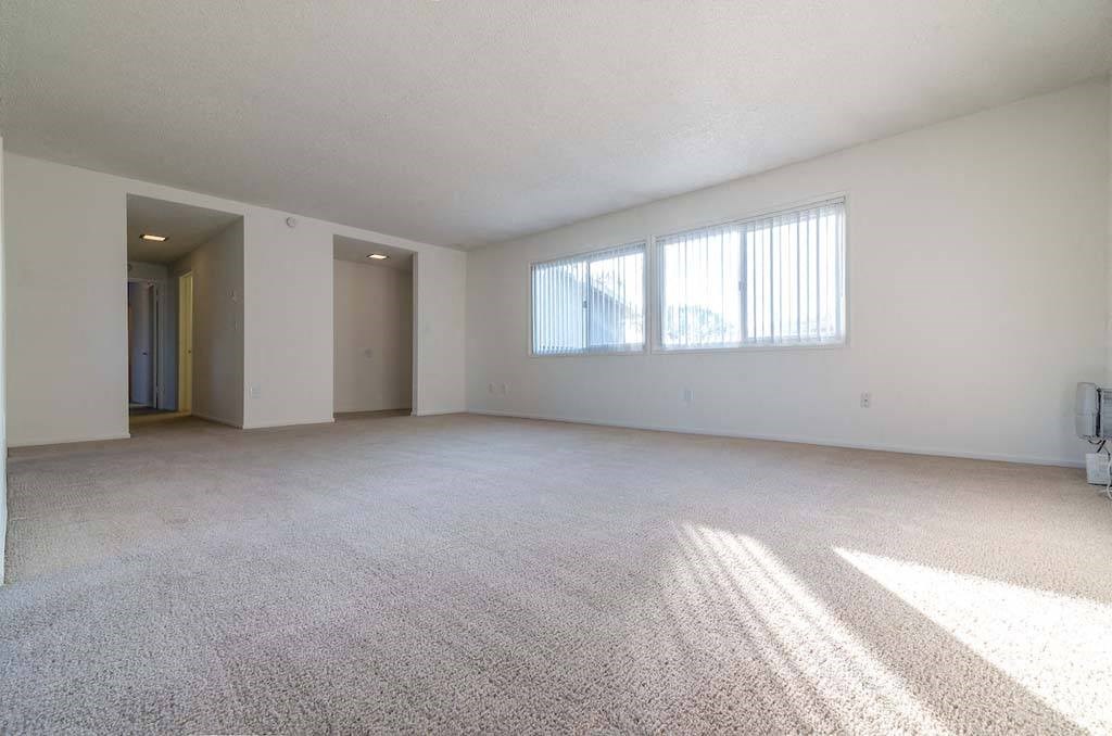 an empty living room with a large window at Park Avenue Apartments, Long Beach, California