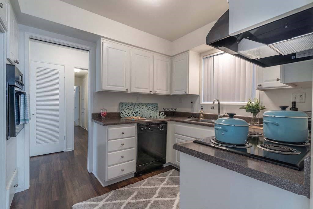 a kitchen with a stove top oven next to a refrigerator at  Park Avenue Apartments, Long Beach