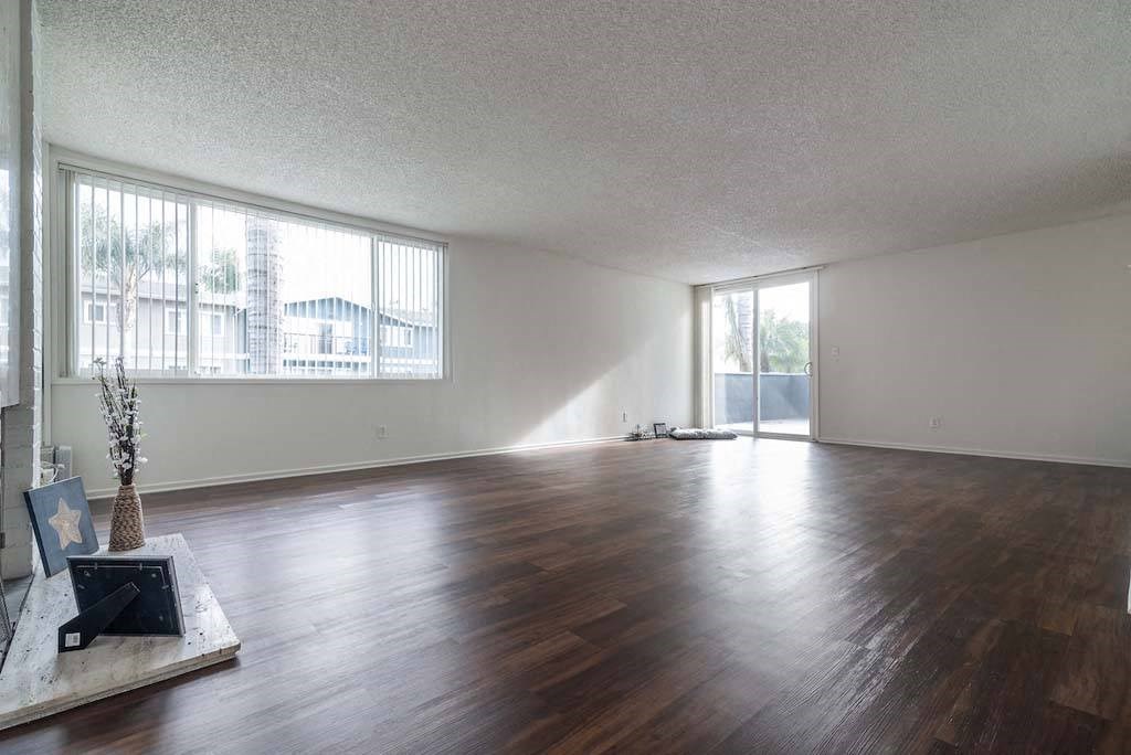 an empty living room with a large window at  Park Avenue Apartments, California