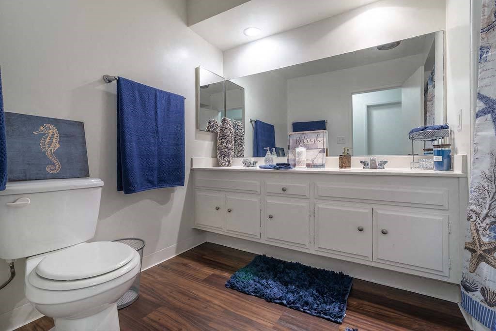 a bathroom with a toilet and a large mirror at Park Avenue Apartments, Long Beach, California