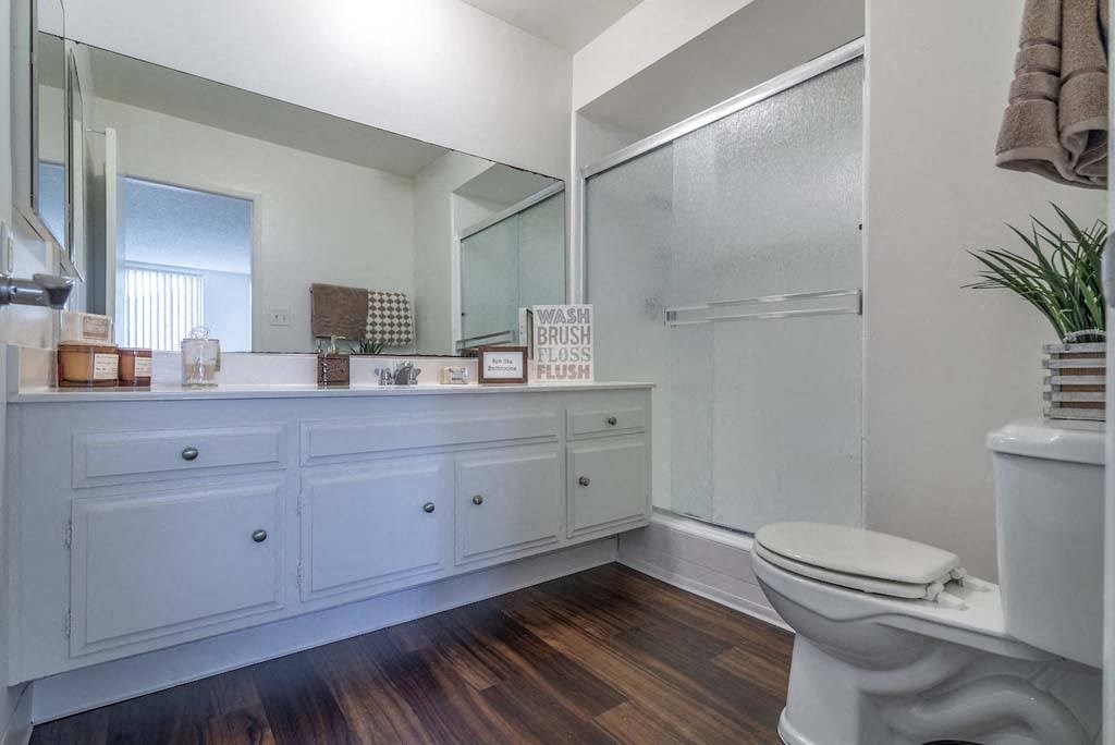 a bathroom with a toilet and a large mirror at Park Avenue Apartments, Long Beach, CA, 90815