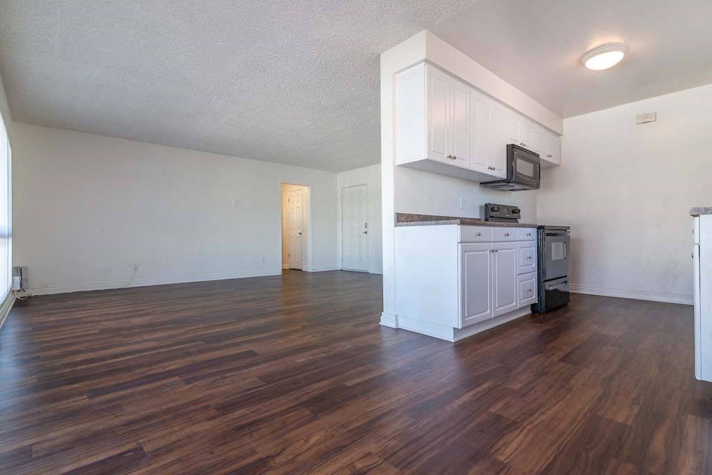 an empty kitchen and living room with hardwood floors at  Park Avenue Apartments, California,90815