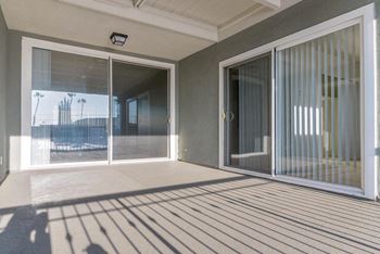 a large patio with sliding glass doors and a striped rug at Park Avenue Apartments, Long Beach, CA