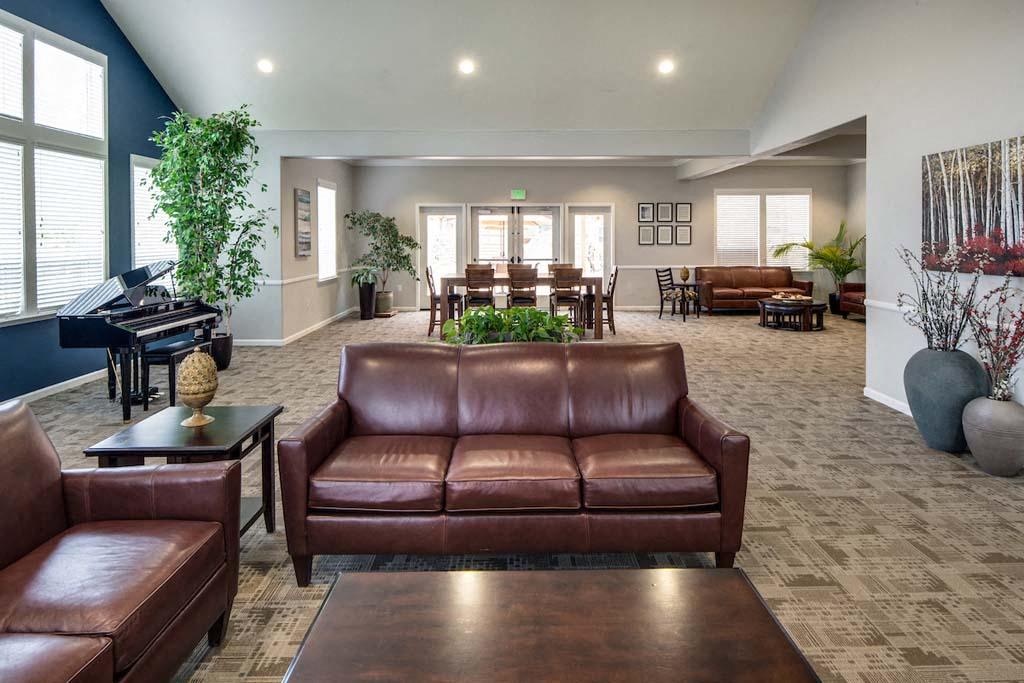 a living room with leather furniture and a piano