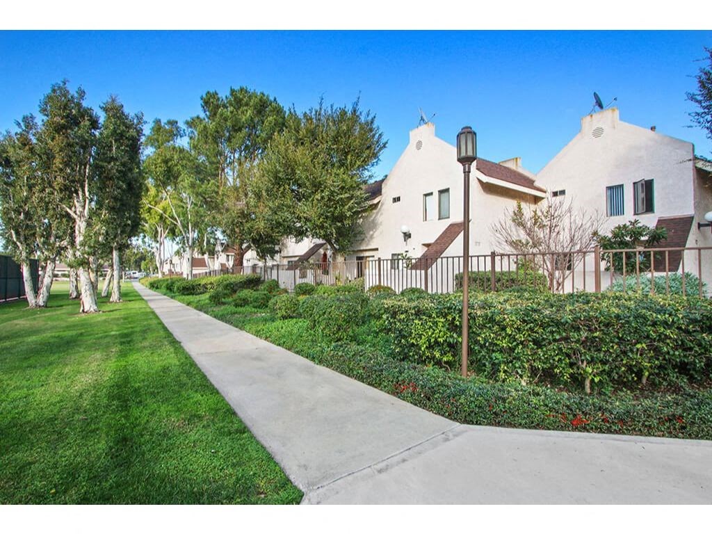 Sidewalk with trees on both sides and houses in the background  at Harvard Manor, Irvine, CA