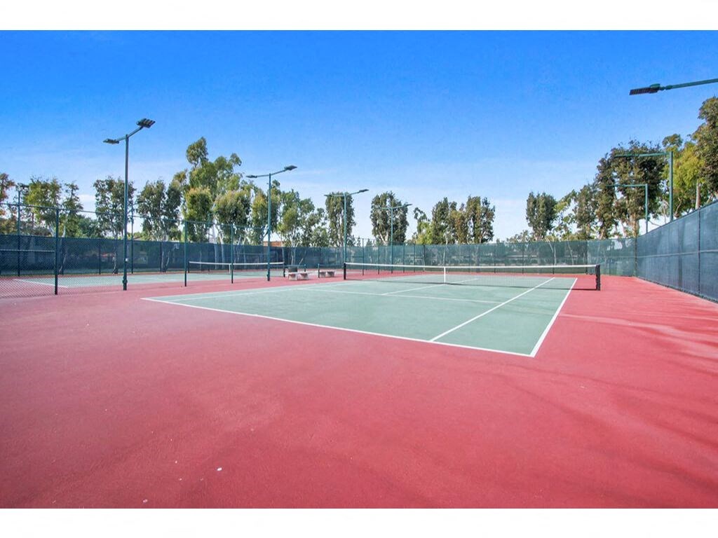 Tennis court with lights and trees in the background  at Harvard Manor, Irvine, CA, 92612