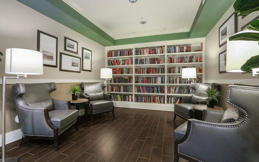 a living room filled with furniture and a large book shelf  at Ventana Senior Apartments, California, 91326