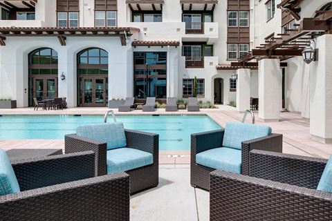 a swimming pool with blue chairs in front of a building  at Deer Creek Apartments, San Ramon, 94582