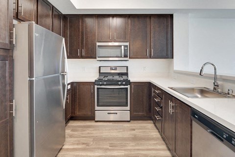 a kitchen with wooden cabinets and stainless steel appliances at Deer Creek Apartments, California, 94582