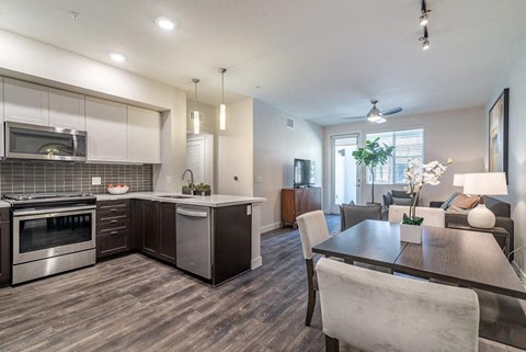 Kitchen with stainless steel appliances and breakfast bar and dining at Montecito Apartments at Carlsbad, Carlsbad, CA