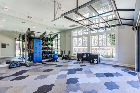 a large room with a lot of windows and a gym equipment at The Vineyards Apartments, California