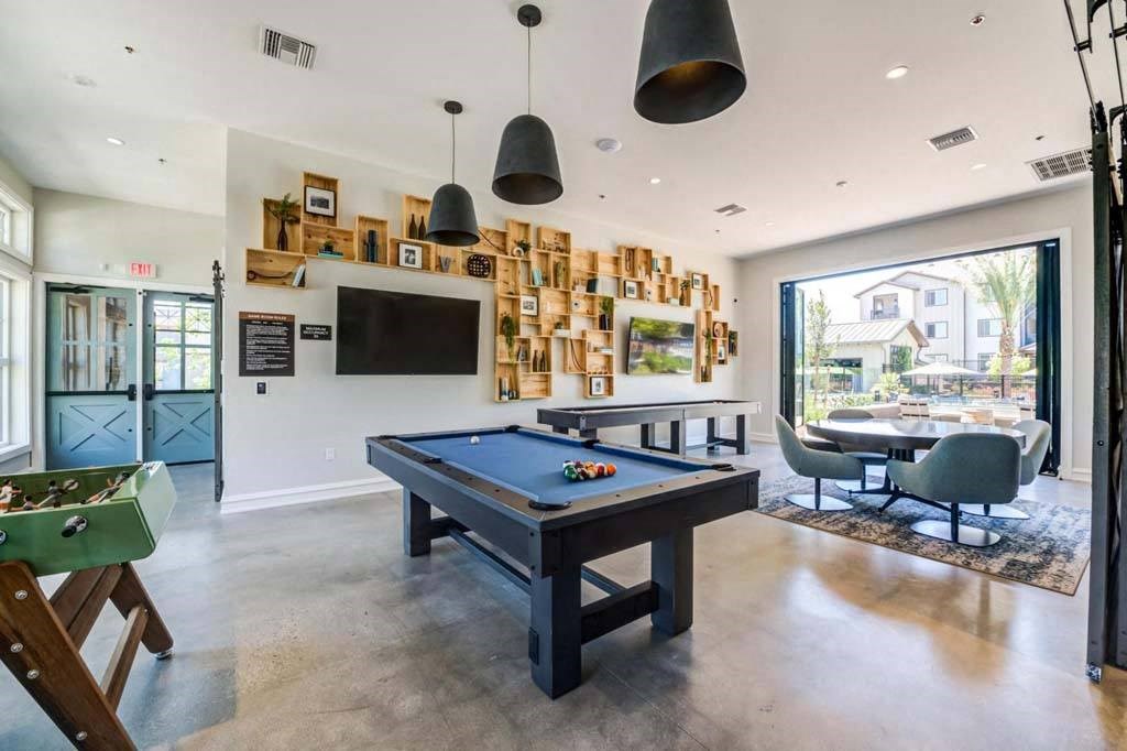 a games room with a pool table and a television at The Vineyards Apartments, Porter Ranch, 91326