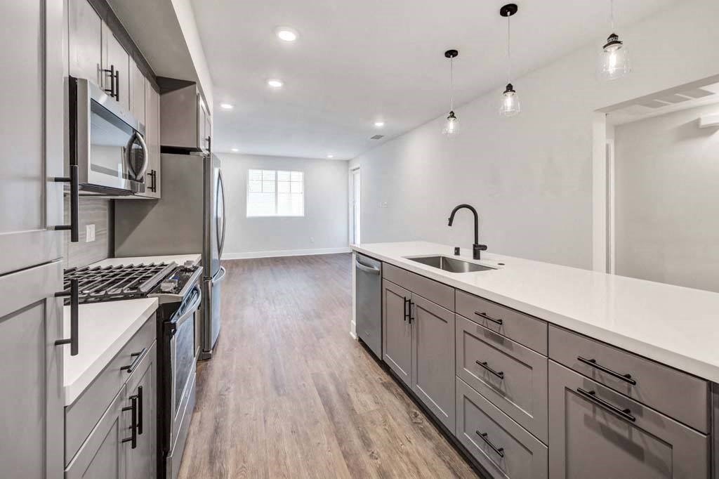 a kitchen with a stove top oven at The Vineyards Apartments, Porter Ranch, CA next to a refrigerator