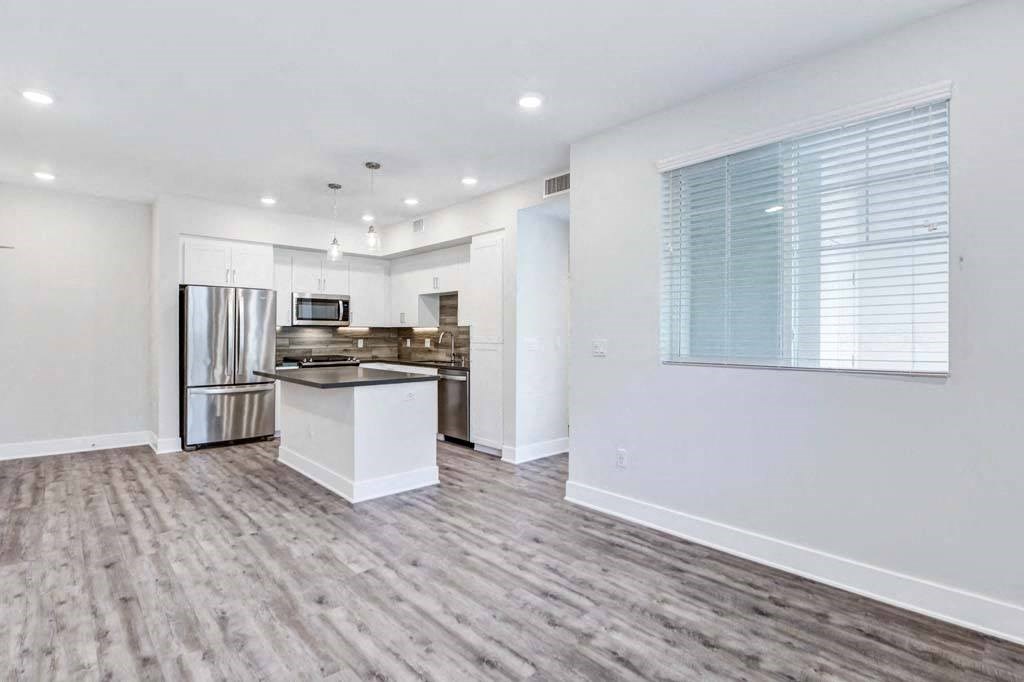 a kitchen with a stove top oven next to a refrigerator at The Vineyards Apartments, California