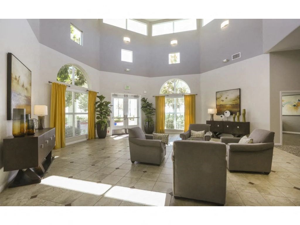a large living room with couches and chairs  at Tesoro Senior Apartments, Porter Ranch, CA, 91326