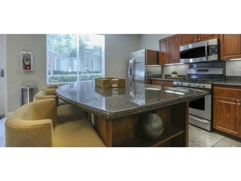 a kitchen with a counter top and a stove top oven  at Tesoro Senior Apartments, California, 91326
