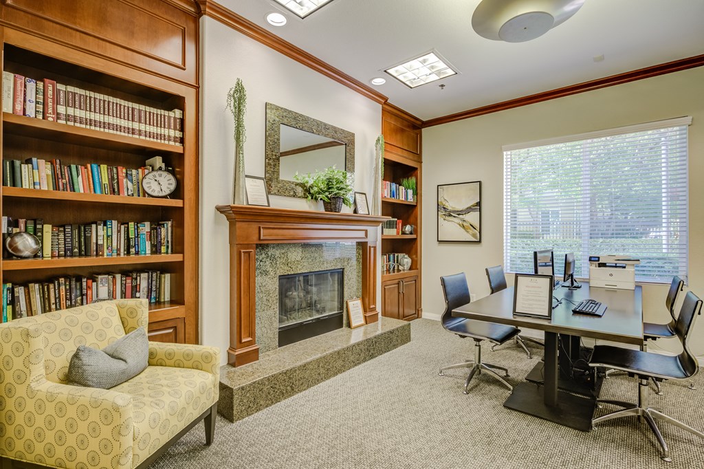 a room with a fireplace and a table and chairs  at Tesoro Senior Apartments, Porter Ranch, California