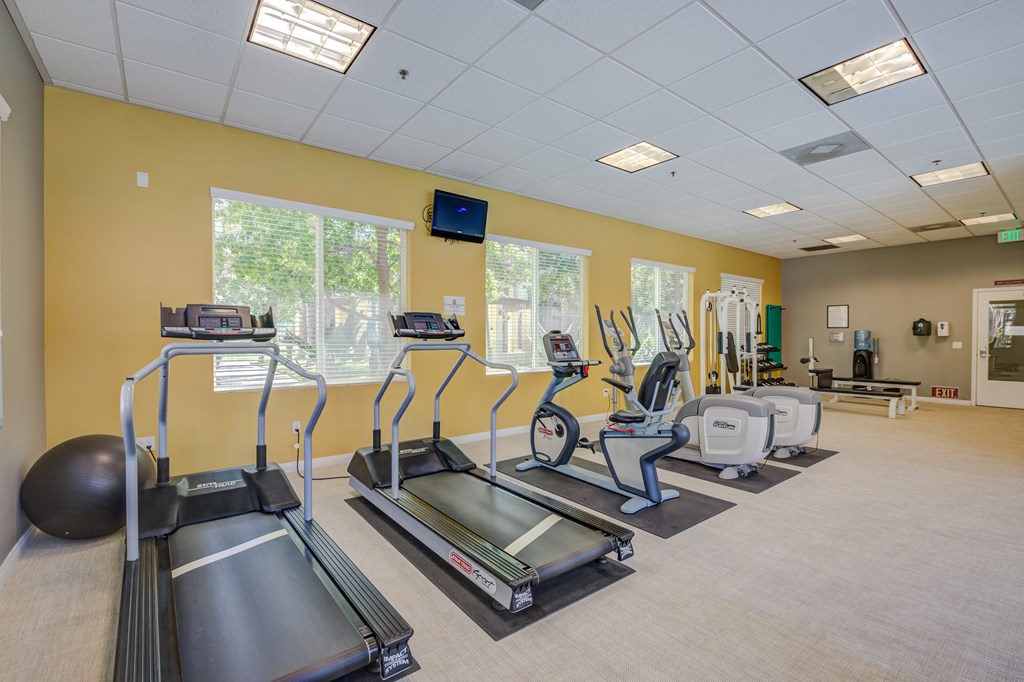 a room filled with lots of exercise equipment at Tesoro Senior Apartments, California