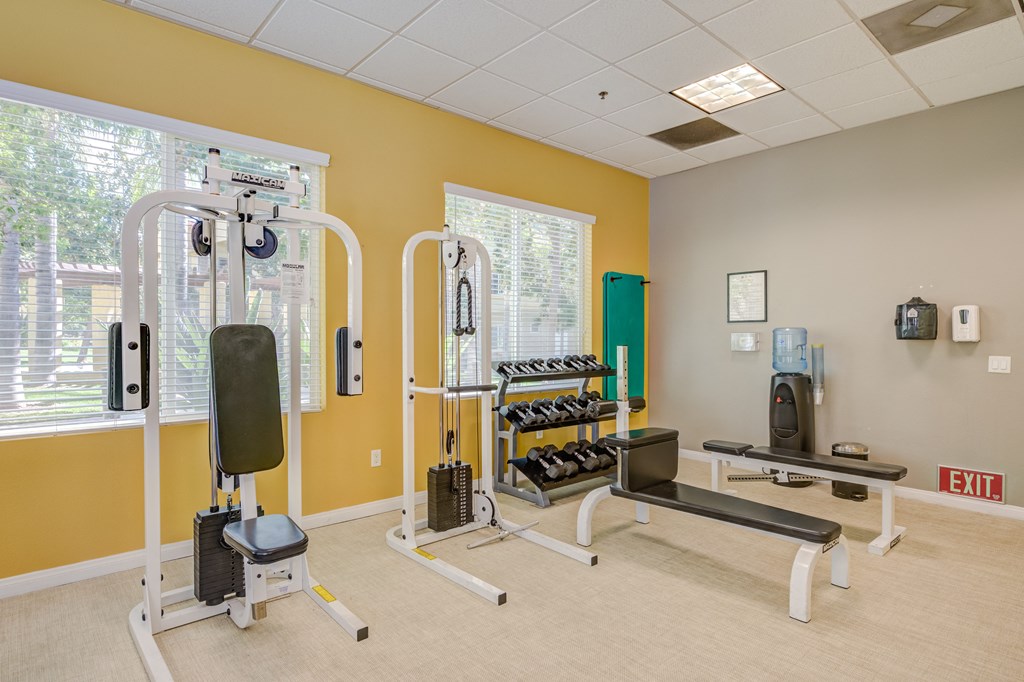 a fitness room with exercise equipment at the whispering winds apartments in pearland, tx  at Tesoro Senior Apartments, Porter Ranch, CA, 91326