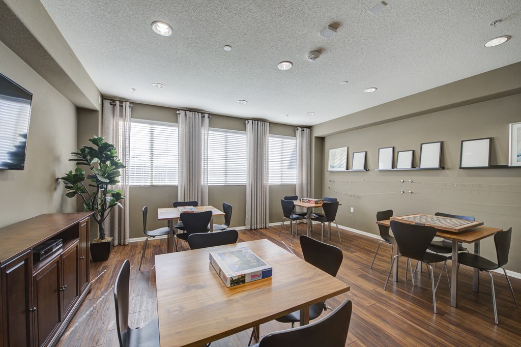 a common area with tables and chairs and a television  at Ventana Senior Apartments, Northridge, CA