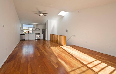a living room with a wooden floor and a ceiling fan