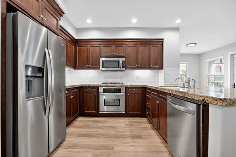 A modern kitchen with wooden cabinets and stainless steel appliances.