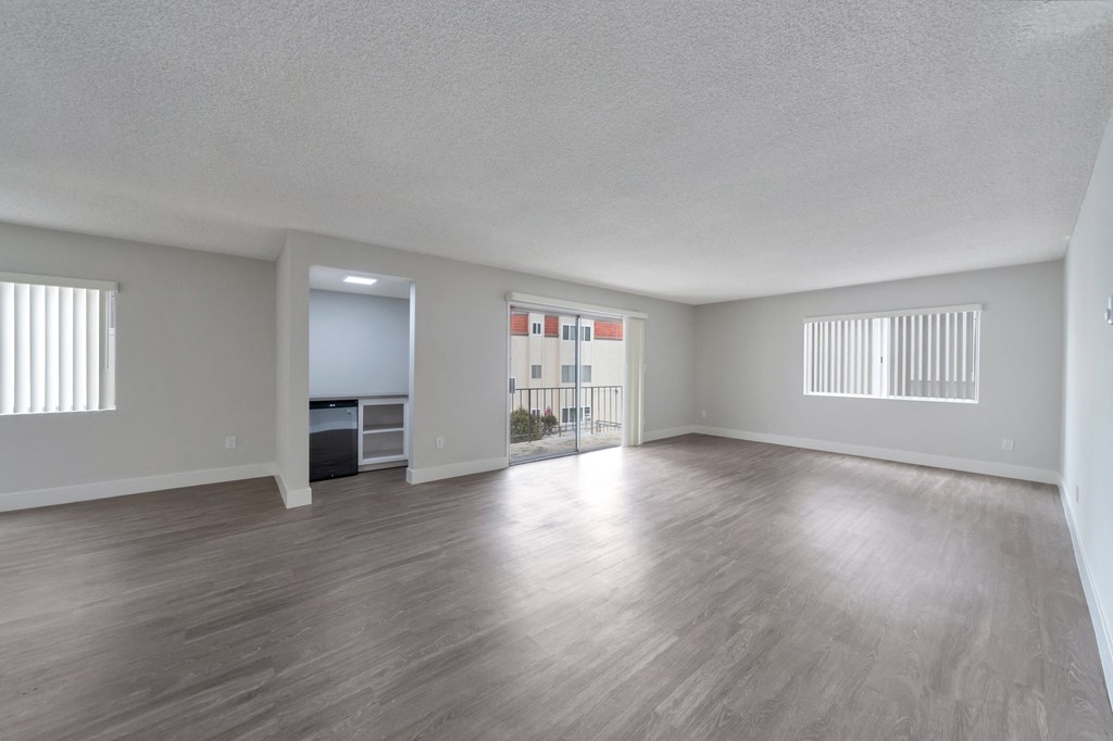 the living room and dining room of an empty apartment with wood flooring at The Mark Culver City, Culver City, CA