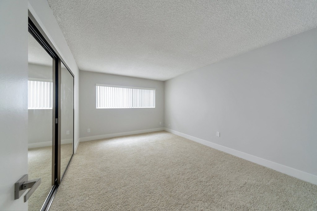 the spacious living room of an apartment with white walls and carpet at The Mark Culver City, Culver City, CA