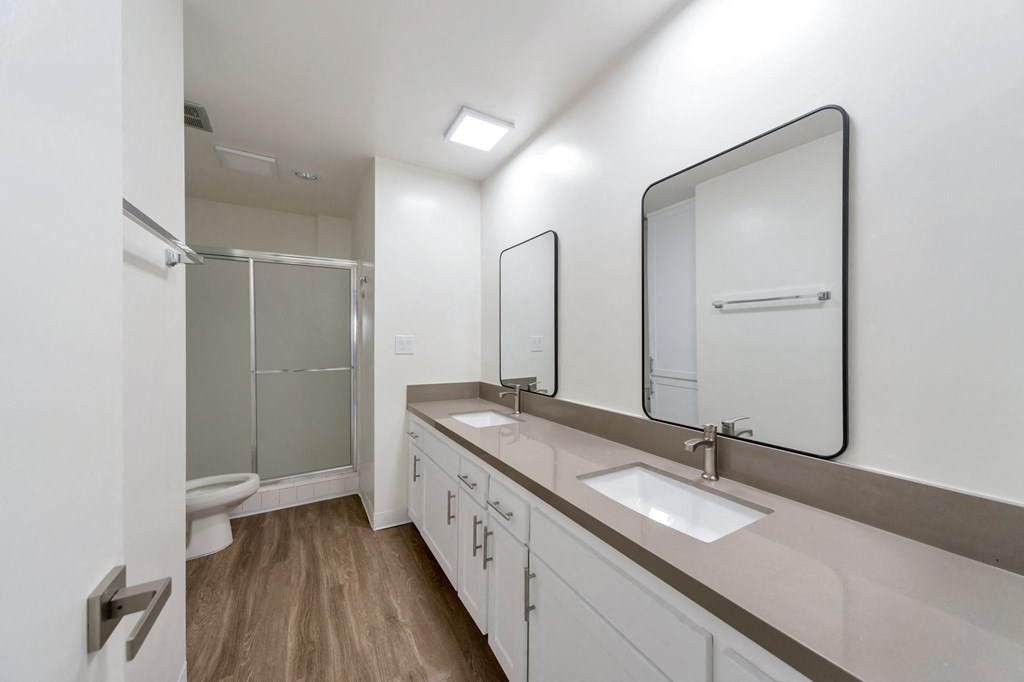 a white bathroom with two sinks and a shower at The Mark Culver City, California