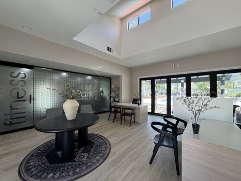 A black table with a white vase on it in a room with a glass wall.