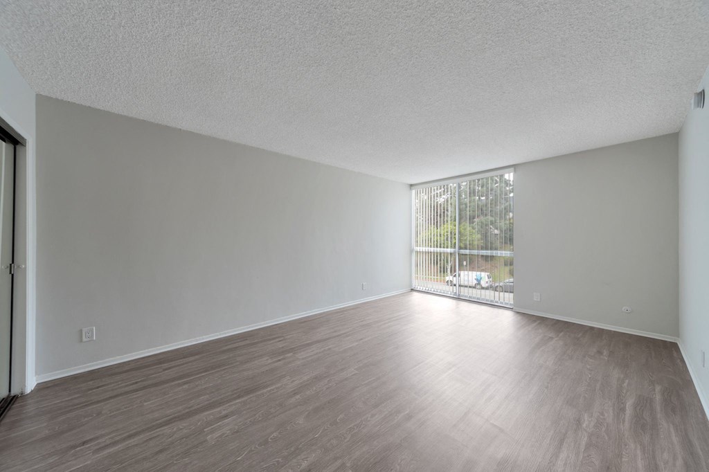 an empty living room with wood flooring and a window at The Mark Culver City, Culver City, California