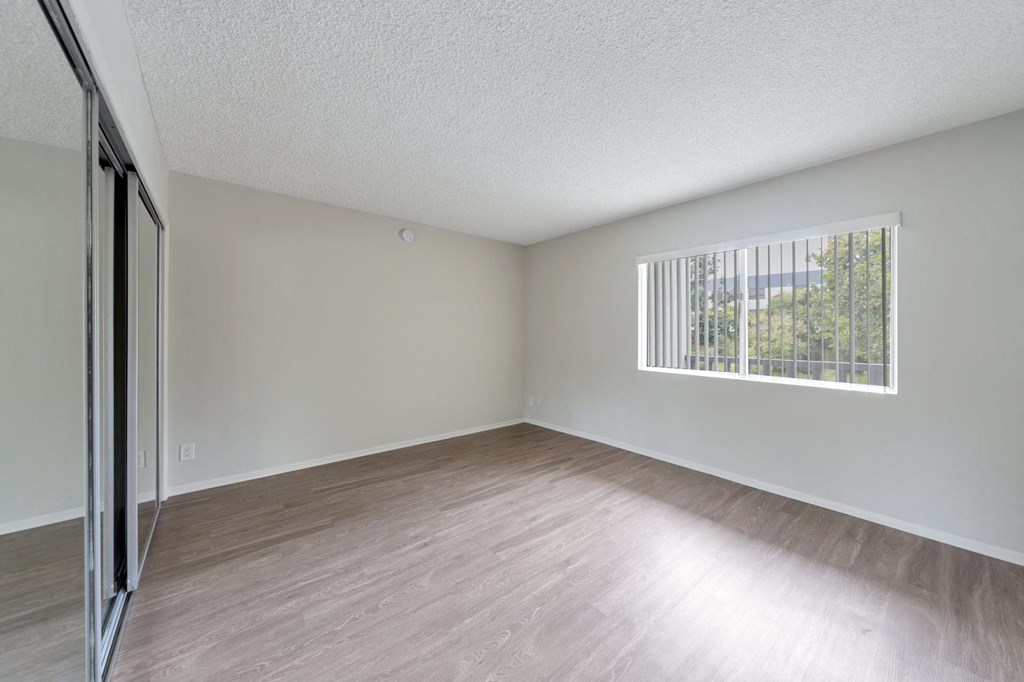 the spacious living room with wood flooring and a window at The Mark Culver City, Culver City, CA, 90230