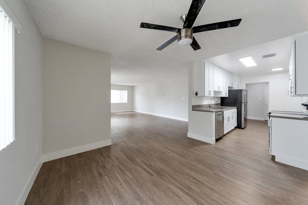 an empty living room and kitchen with a ceiling fan at The Mark Culver City, California, 90230