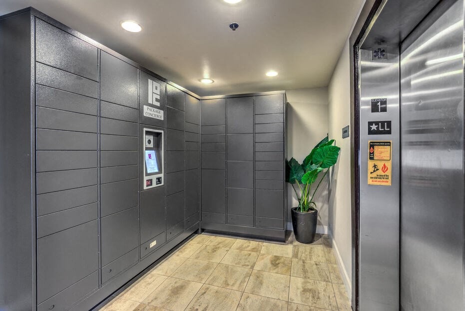 a lobby with elevators and a potted plant