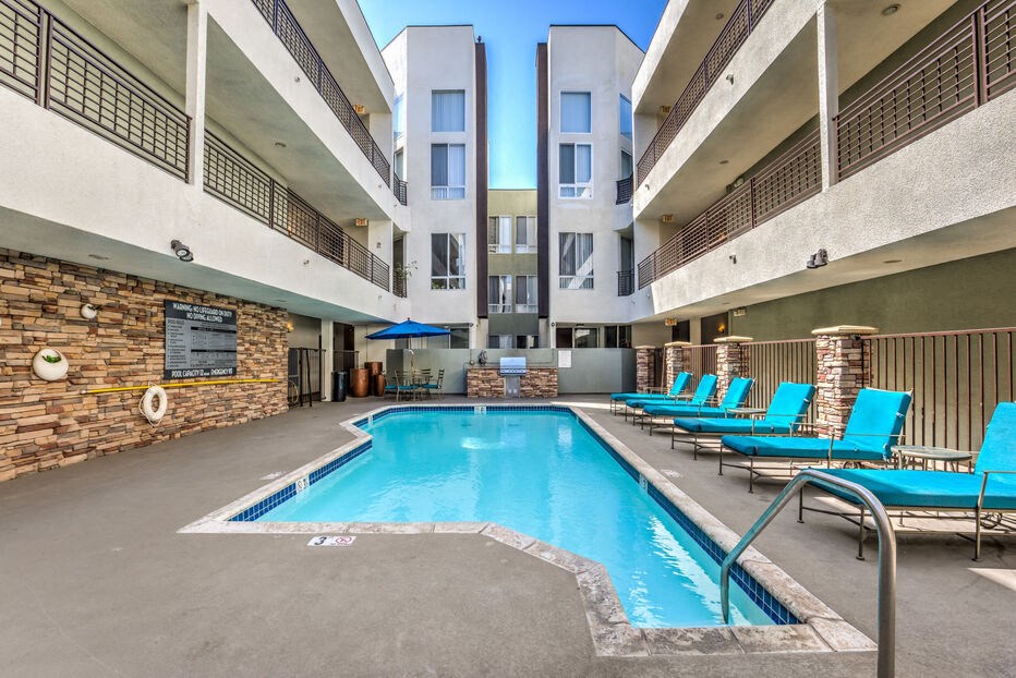a swimming pool in the middle of a building with blue chairs