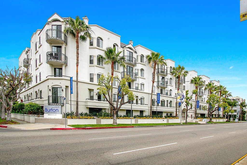 a white building with palm trees in front of a street at Burton, Los Angeles, California