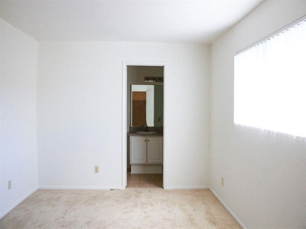 an empty room with a sink and a mirror