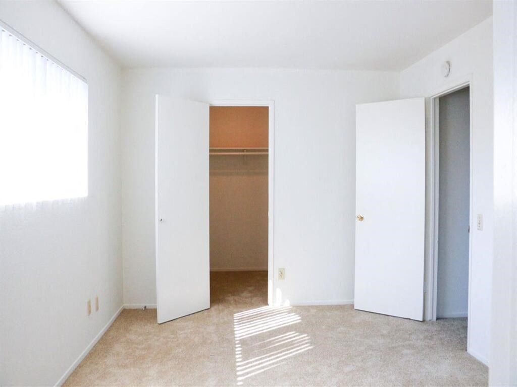 an empty room with a closet and a window