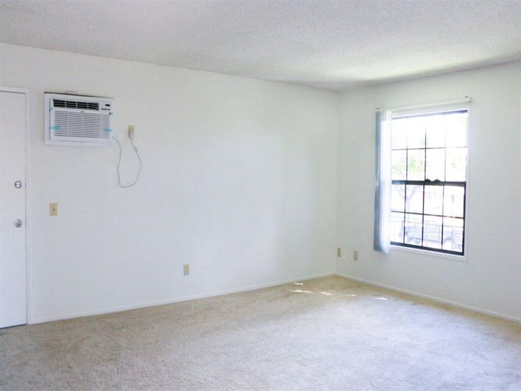 an empty room with a window and an air conditioner