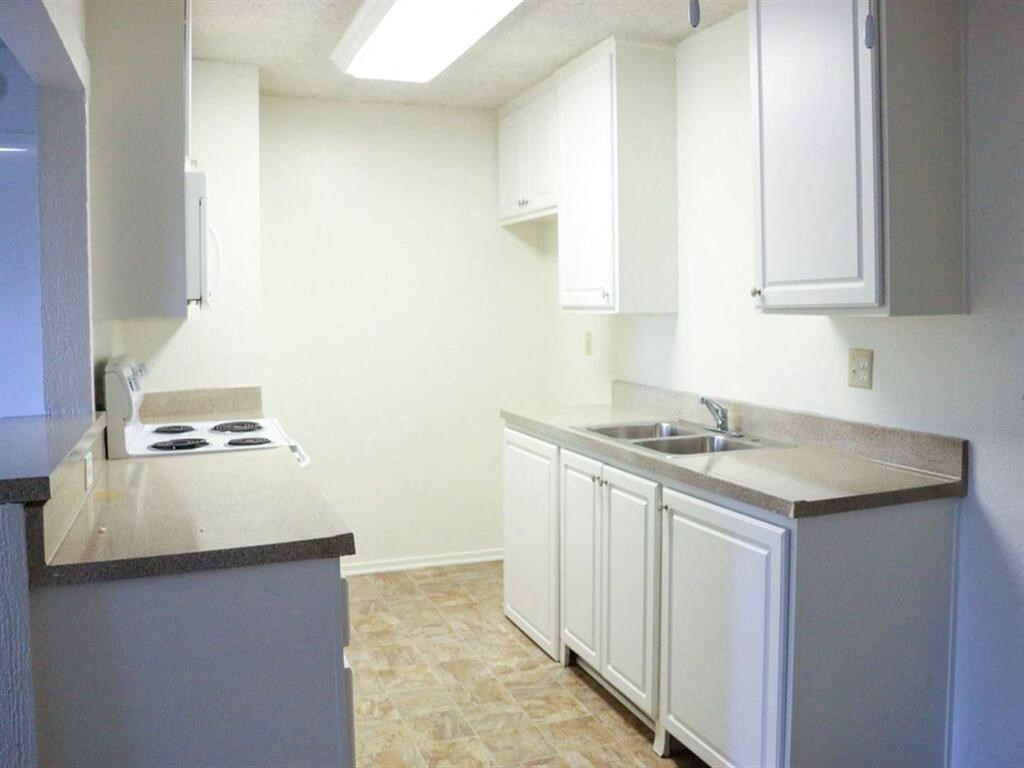 a kitchen with white cabinets and a white stove top oven