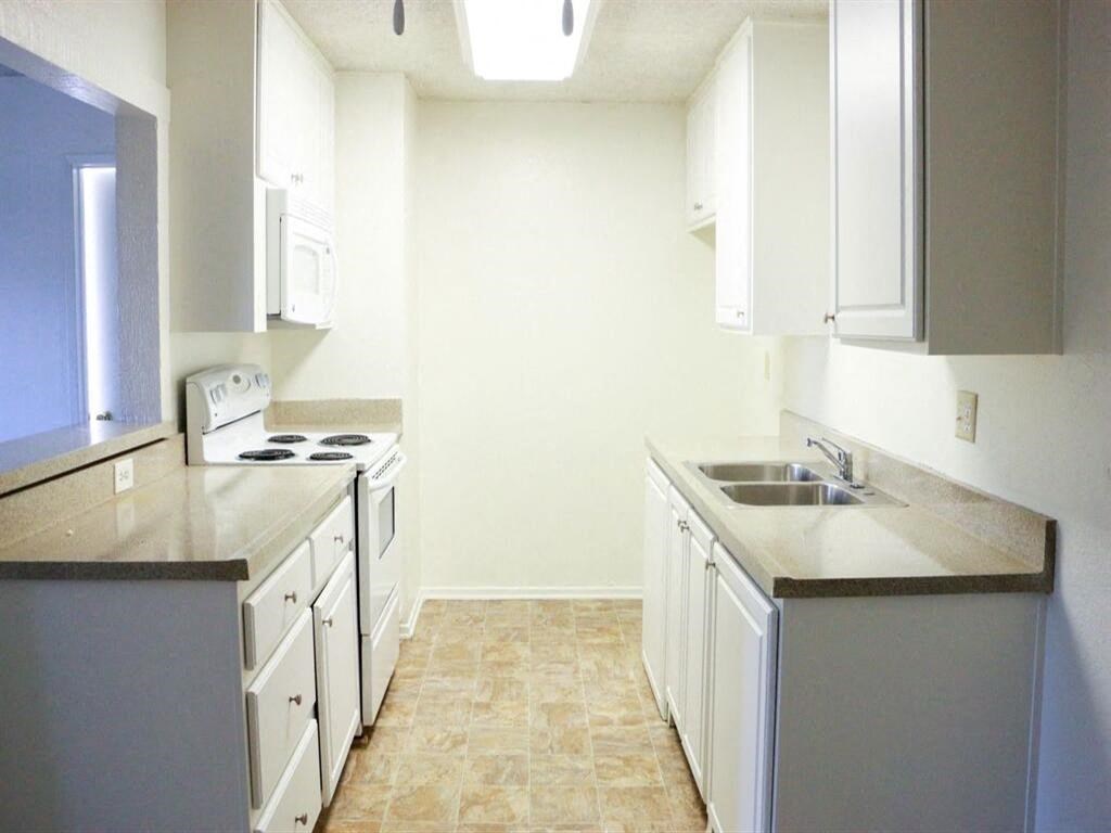 a kitchen with a stove top oven next to a sink