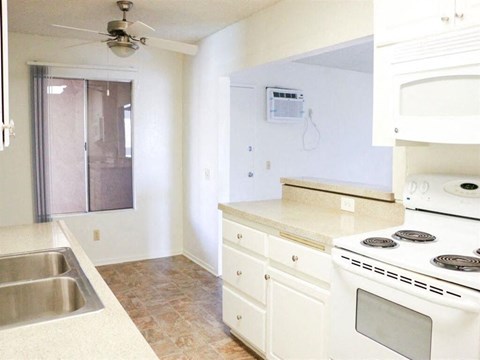 an empty kitchen with a stove and a sink