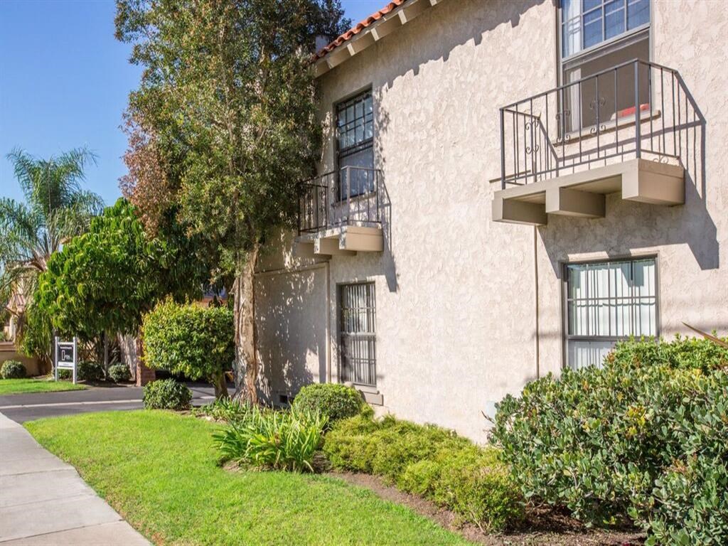 a building with two balconies and a sidewalk in front of it