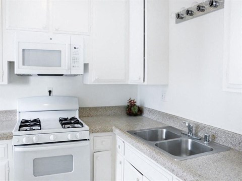 a white kitchen with white appliances and white cabinets