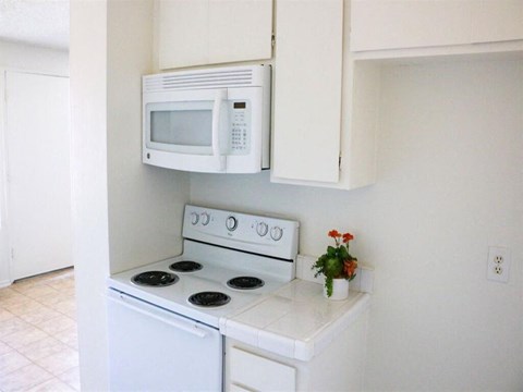 a white kitchen with a stove and a microwave