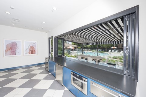 A modern kitchen with a checkered floor and a large window.