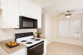 a kitchen with white cabinets and a black stove top oven